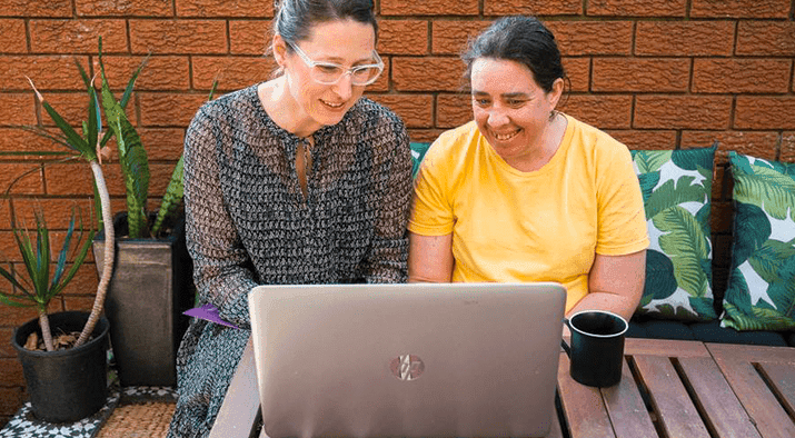 Person with disability smiling at camera at desk